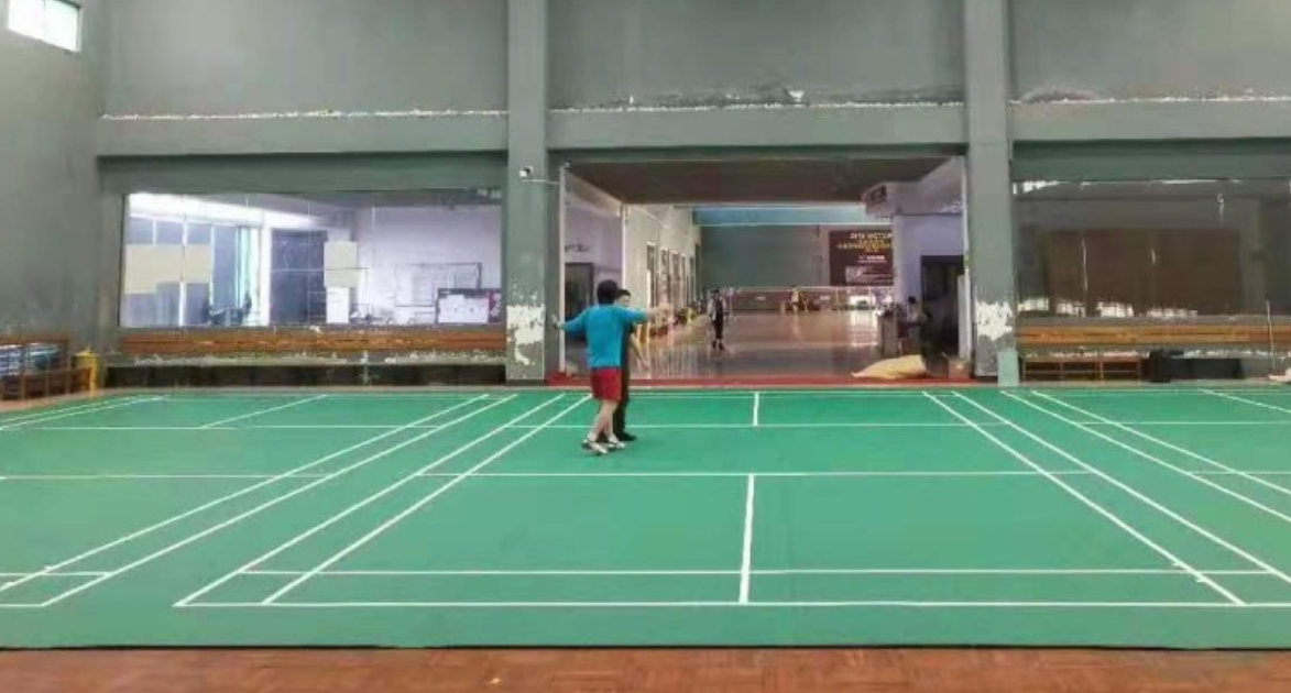 Sand overflategulv som brukes til innendørs badmintonbane