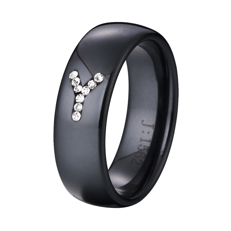Juodas keramikinis žiedas, inkrustuotas žodžio linija Y, sudaryta iš krištolo