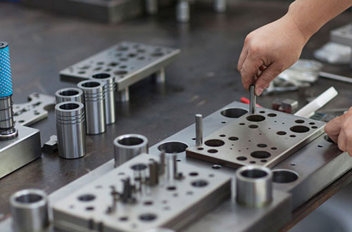What are the structural components of the progressive stamping die?